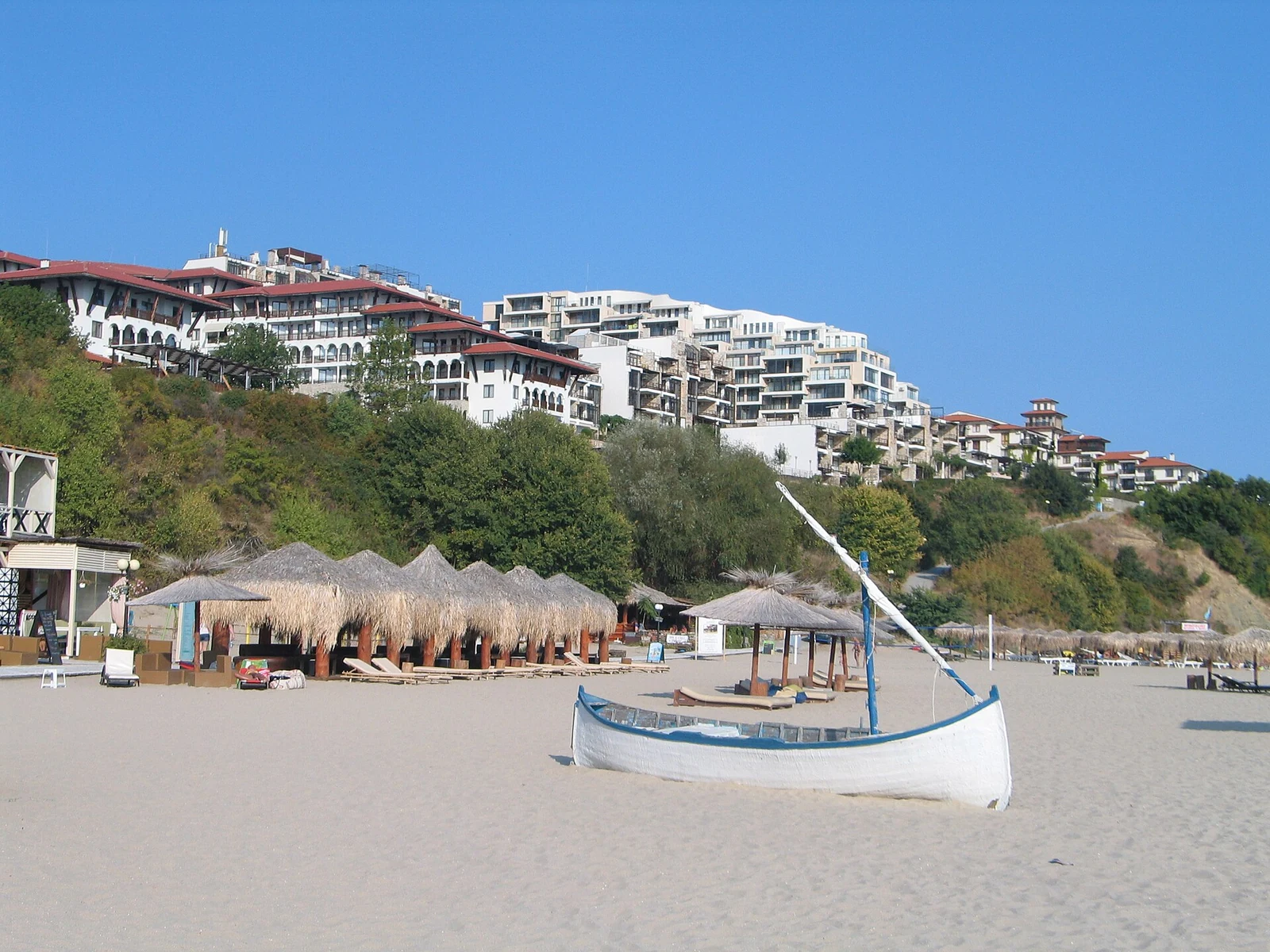 Plaża z łodzią i budynkami na skarpie w Sveti Vlas
