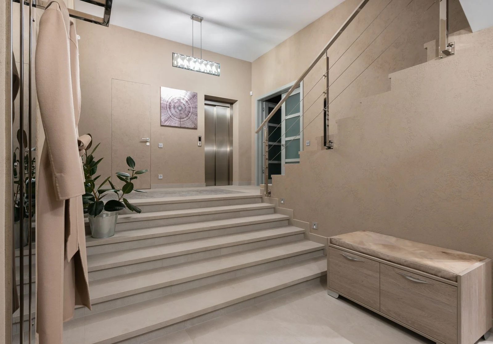 Jasne lobby ze schodami, balustradą i windą