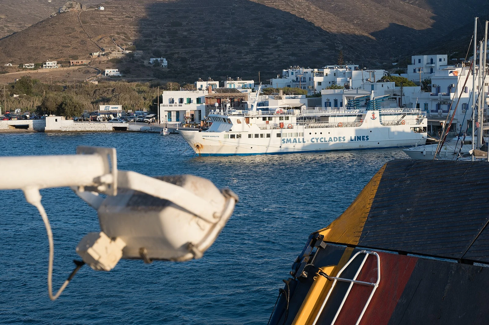 Prom Small Cyclades Lines przy zabudowie portu Katapola na Amorgos, widziany z pokładu innej jednostki