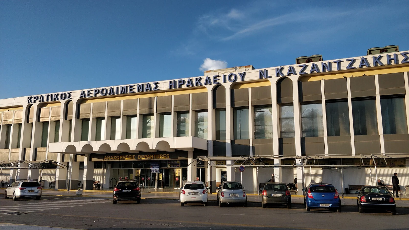 Fasada terminala lotniska Heraklion z wejściem Departures i samochodami od strony ulicy