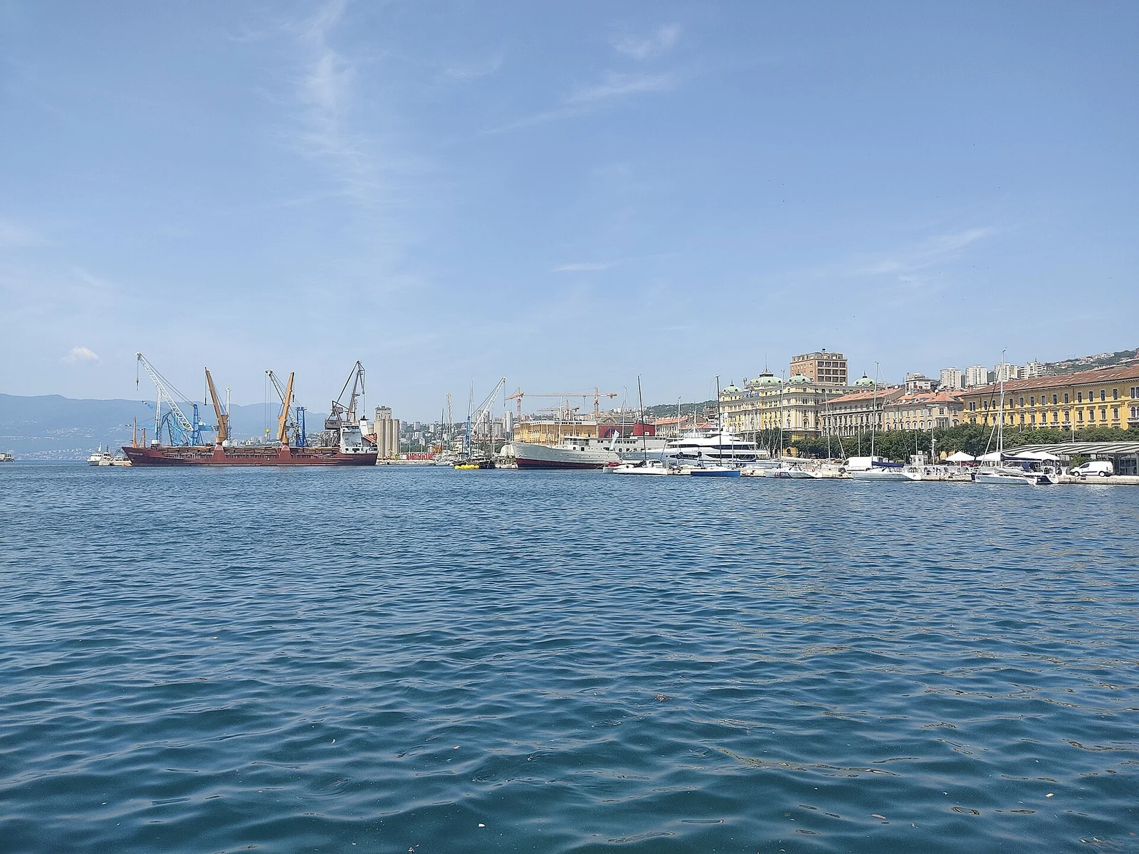 Woda, nabrzeże, zabudowa i dźwigi portowe w Rijece