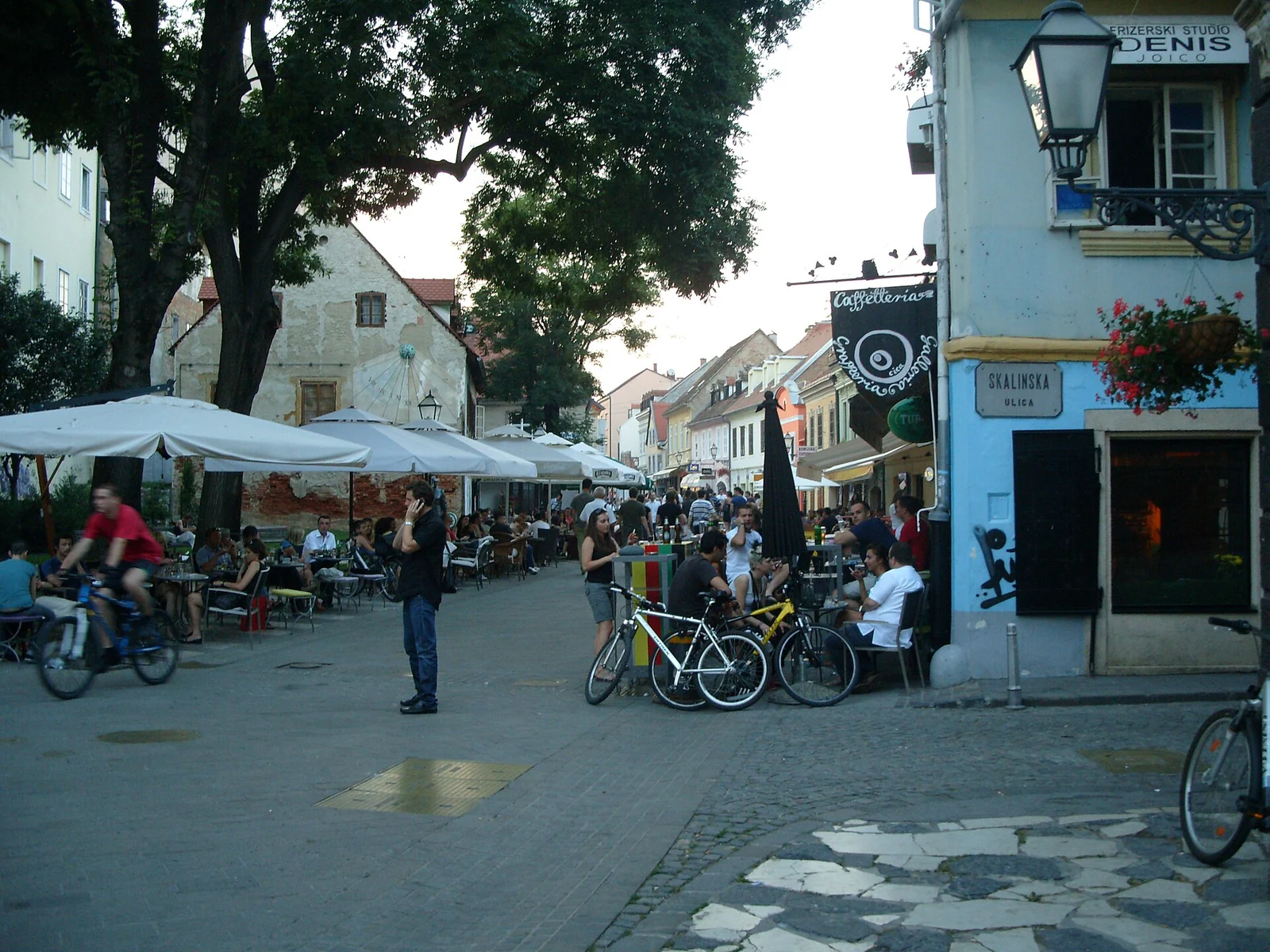 Stoliki kawiarni, piesi i rowery na ulicy w Zagrzebiu