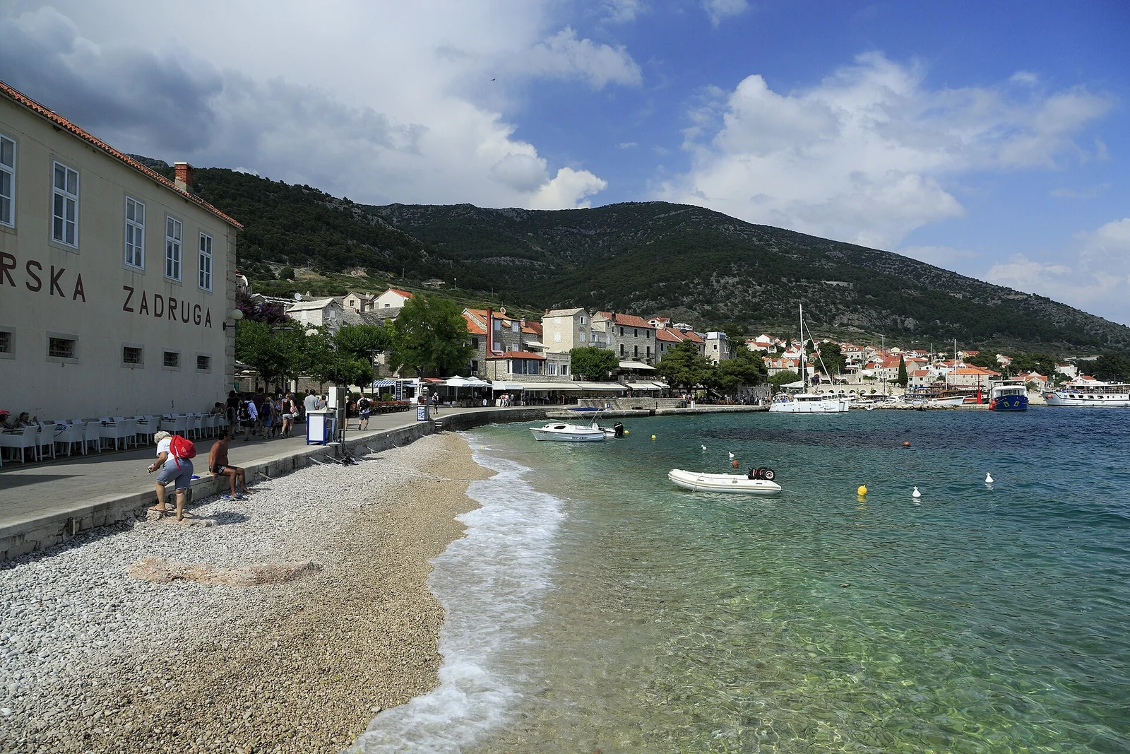 Nabrzeże Riva w Bolu na Braču, z małą plażą i zabudową przy wodzie